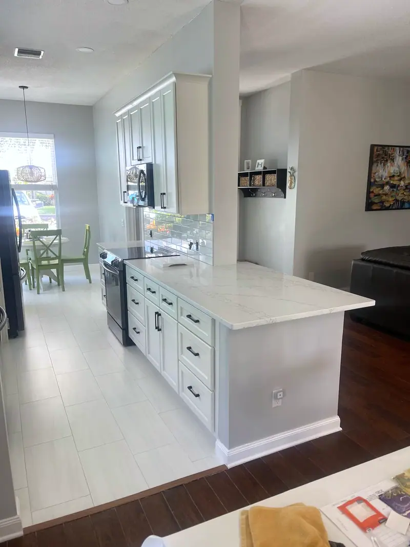 Cocina abierta con una isla blanca que da a la sala